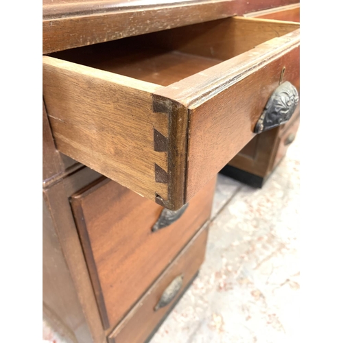 712 - A 1930s H. Baldock & Son of Liverpool mahogany pedestal desk with seven drawers and half moon handle... 