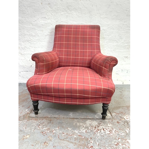 713 - A Victorian red upholstered library armchair on ebonized supports