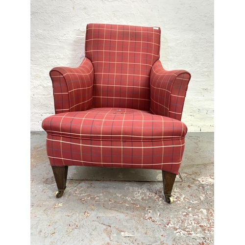 714 - An Edwardian red upholstered library armchair on brass castors