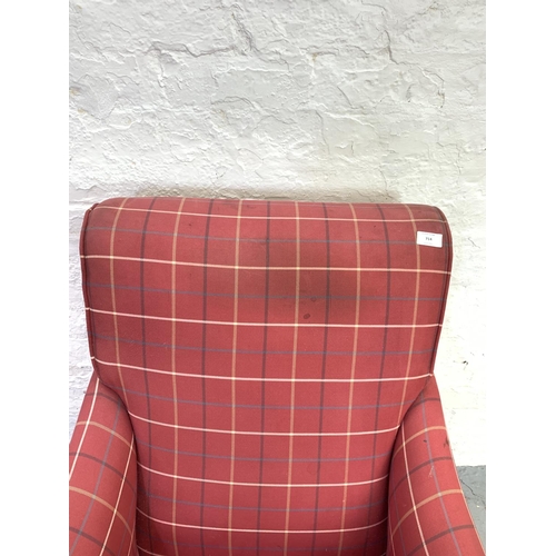 714 - An Edwardian red upholstered library armchair on brass castors