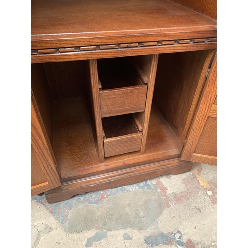 720 - An oak media cabinet with two lower doors and two upper glazed doors - approx. 114cm high x 54cm wid... 