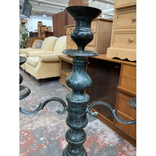 735 - An aged bronze effect floor standing three branch candelabra - approx. 97cm high x 46cm wide