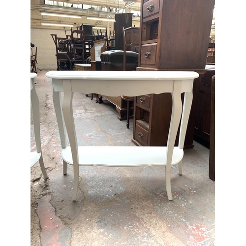 756 - Two modern white painted serpentine two tier console tables - approx. 78cm high x 94cm wide x 32cm d... 