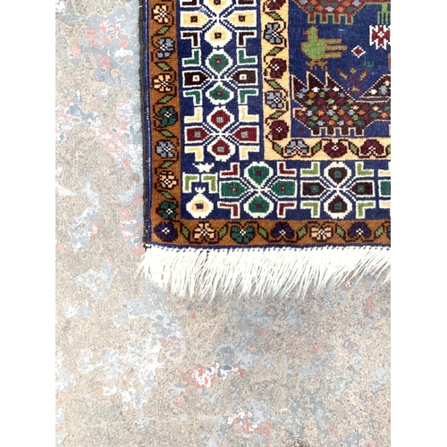 785 - A Middle Eastern Baluch rug with peacock design and repeated border - approx. 198cm x 105cm