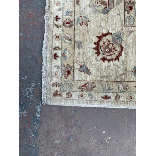 787 - A large oriental cream and red 100% wool rug - approx. 357cm x 280cm