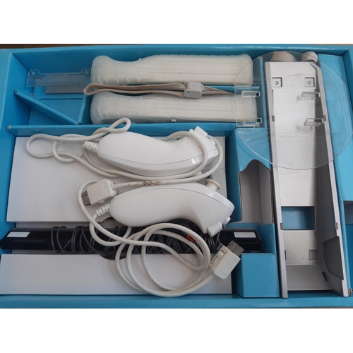 1069 - A boxed Nintendo Wii console with balance board, two controllers, two nunchuks, power supply and sev... 