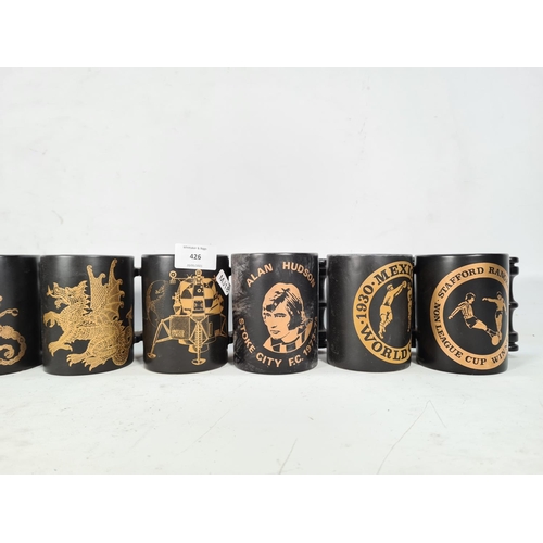 426 - Eight various Portmeirion Pottery black and gold mugs to include Stoke City F.C 1972 League Cup Winn... 