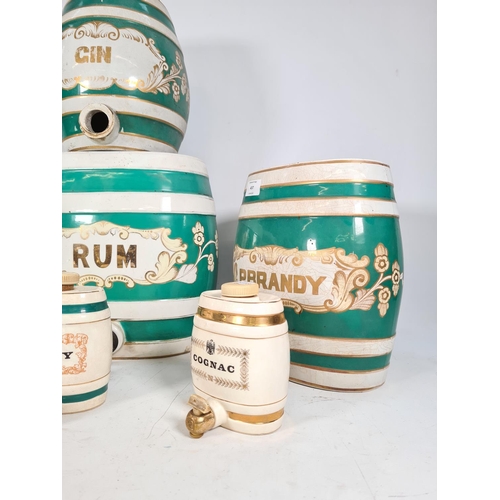 437 - Seven various ceramic liquor barrels, four vintage green & white barrels to include 'rum', 'pear bra... 