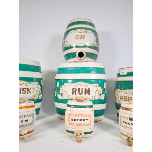 437 - Seven various ceramic liquor barrels, four vintage green & white barrels to include 'rum', 'pear bra... 