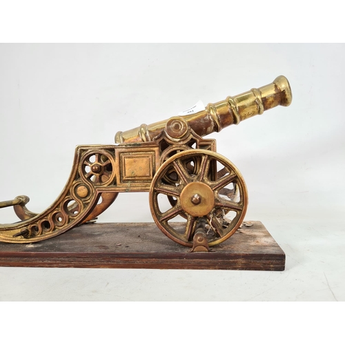 491 - A vintage brass ornamental cannon on wooden plinth - approx. 23cm high x 15cm wide x 45cm deep