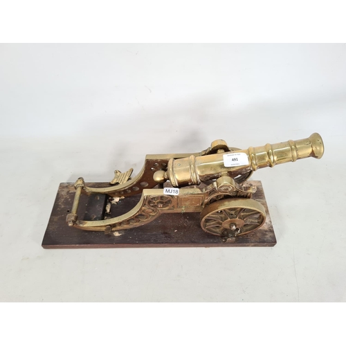 491 - A vintage brass ornamental cannon on wooden plinth - approx. 23cm high x 15cm wide x 45cm deep