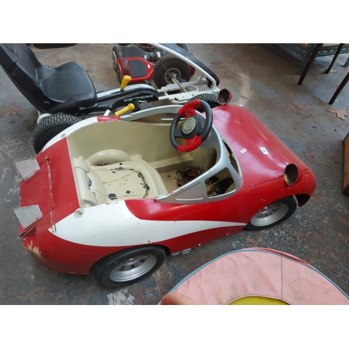 1204 - A red and white child's ride on electric car together with a child's ride on pedal tractor, front lo... 