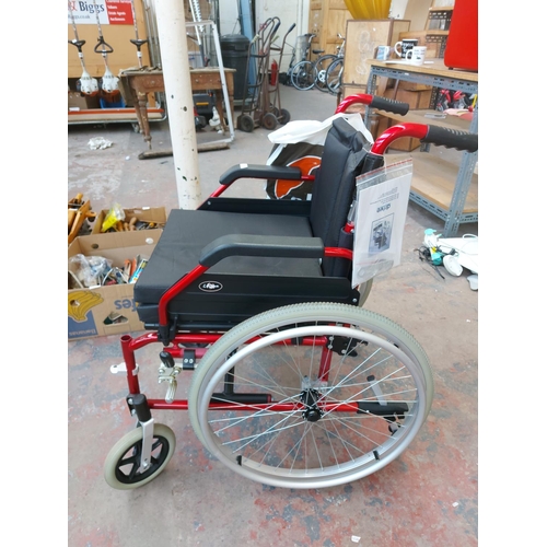 1208 - A black and red Enigma folding self propelled wheelchair with footrests and instruction manual