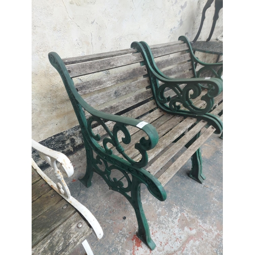 1218 - A pair of wooden slatted garden chairs on heavy duty green painted cast iron supports