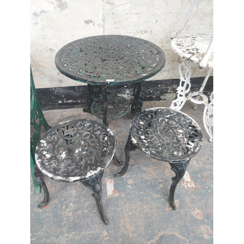 1219 - Nine items to include four stackable black metal patio chairs, cast aluminium circular patio table w... 