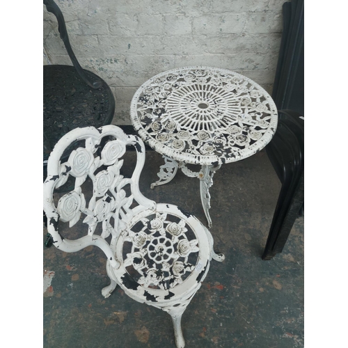 1219 - Nine items to include four stackable black metal patio chairs, cast aluminium circular patio table w... 