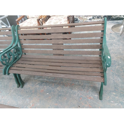 1225 - Two items, one wooden slatted three seater garden bench and one chair on green painted ornate cast i... 