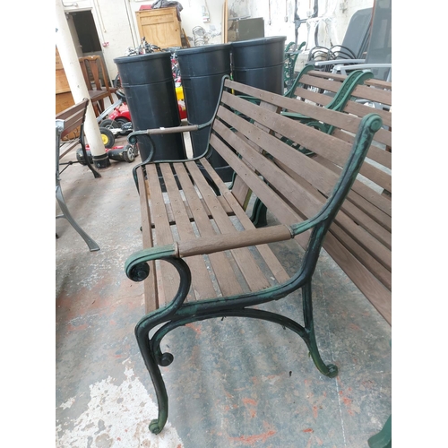 1226 - A wooden slatted three seater garden bench on cast iron supports