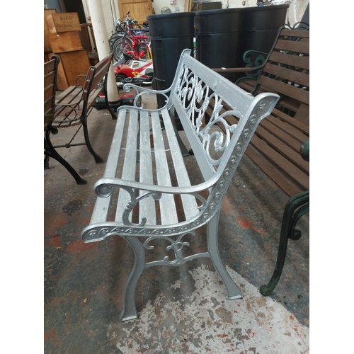 1227 - A wooden slatted silver painted three seater garden bench on cast iron supports