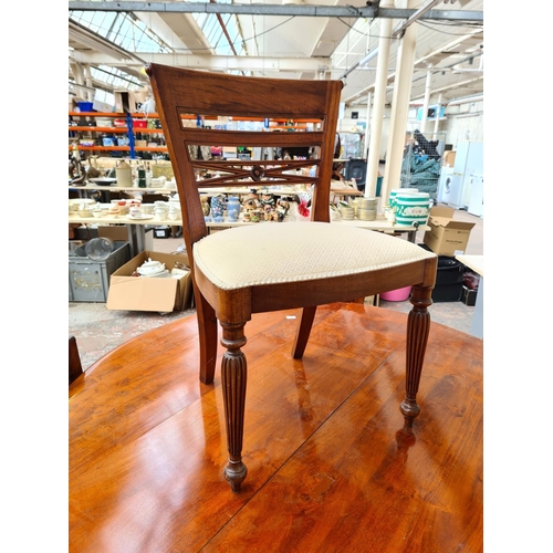 745 - A stained pine circular dining table and four chairs with white upholstered seats - approx. 147.5cm ... 