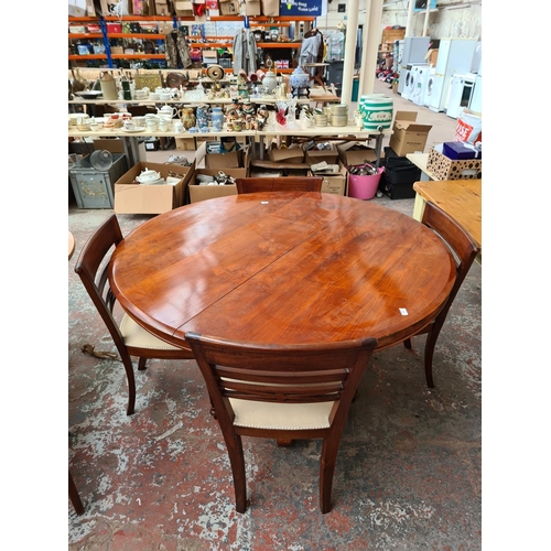 745 - A stained pine circular dining table and four chairs with white upholstered seats - approx. 147.5cm ... 