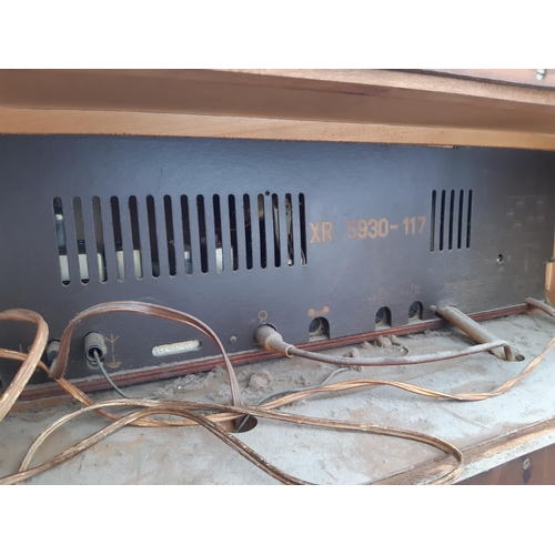 1128 - A polished walnut veneered stereo radiogram fitted with Garrard 1025 four speed auto changer turntab... 