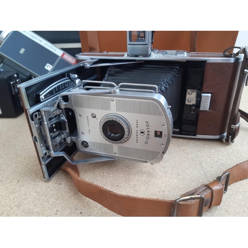 1190 - A box containing cameras and photography equipment to include cased Polaroid model 95B land camera, ... 