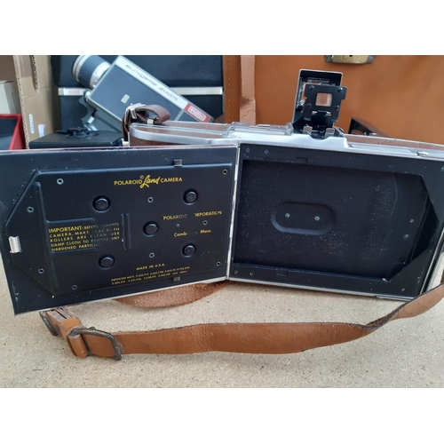 1190 - A box containing cameras and photography equipment to include cased Polaroid model 95B land camera, ... 