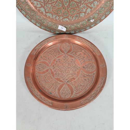 488 - Two Middle Eastern copper wall chargers - the largest approx. 45cm diameter