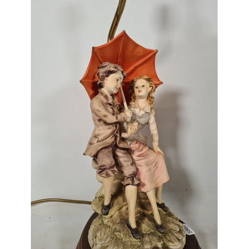 600 - Two tables lamps, one Capodimonte style boy and girl with umbrella - approx. 45cm high and one orien... 