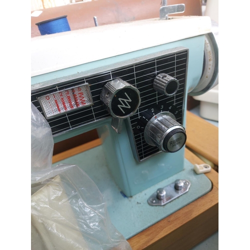 1137 - Two cased vintage electric sewing machines, one green and white Alfa and one blue and green Jones bo... 