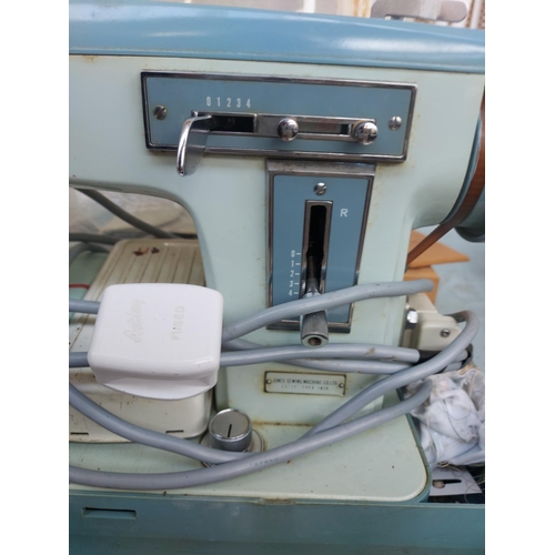 1137 - Two cased vintage electric sewing machines, one green and white Alfa and one blue and green Jones bo... 