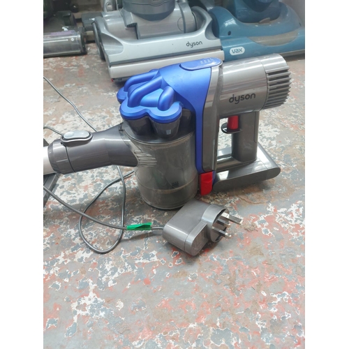 1162 - A blue and grey Dyson handheld cordless bagless vacuum cleaner with charging station and attachments