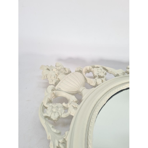 572 - A Victorian style cream painted oval wall mirror with floral design - approx. 73cm x 41cm