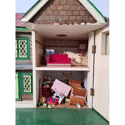 620 - A vintage hand painted two storey dolls house with a large quantity of furniture and accessories