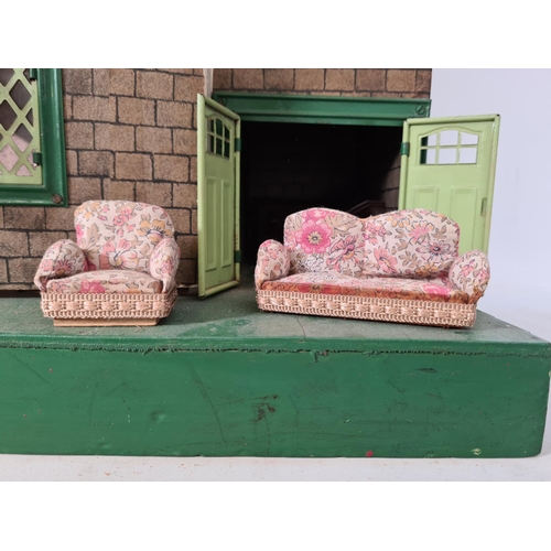 620 - A vintage hand painted two storey dolls house with a large quantity of furniture and accessories