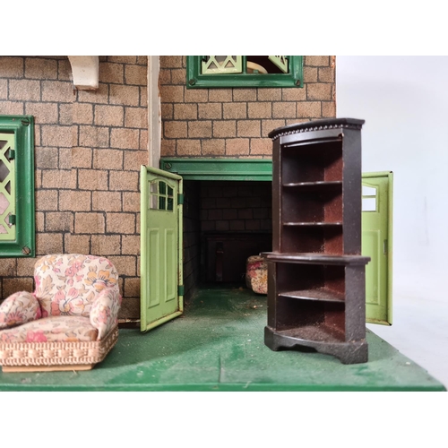 620 - A vintage hand painted two storey dolls house with a large quantity of furniture and accessories