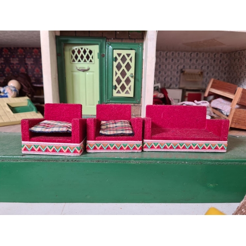 620 - A vintage hand painted two storey dolls house with a large quantity of furniture and accessories