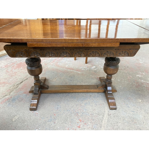 673 - An 18th century style oak draw leaf dining table on baluster supports - approx. 76cm high x 182cm lo... 