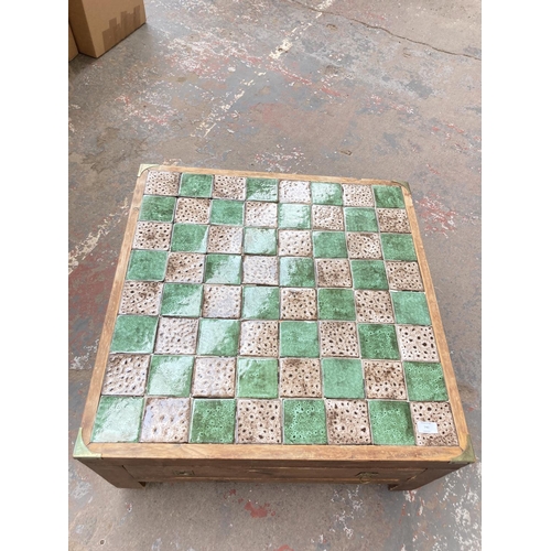 740 - A pine and tile top square chess board/coffee table with campaign style handles and chess pieces - a... 