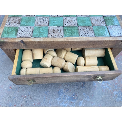 740 - A pine and tile top square chess board/coffee table with campaign style handles and chess pieces - a... 