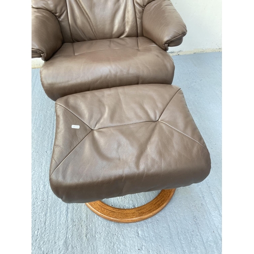 797 - A Stressless style brown leather swivel armchair with matching footstool