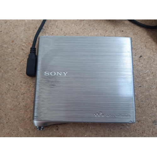 Three MiniDisc players, one Sony MZ-E10 Walkman with remote