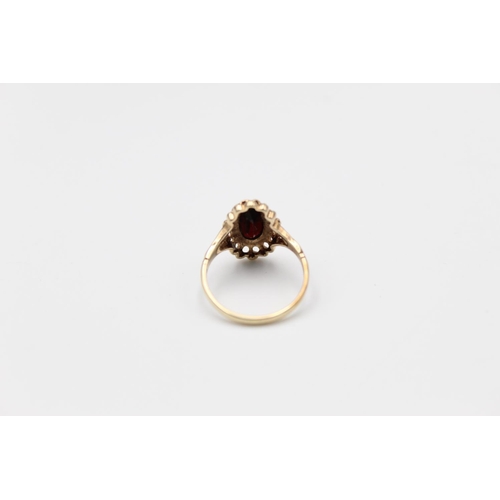 84 - A 9ct gold ornate garnet set ring, size O - approx. gross weight 2.6 grams