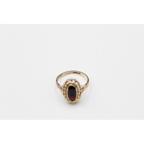 84 - A 9ct gold ornate garnet set ring, size O - approx. gross weight 2.6 grams