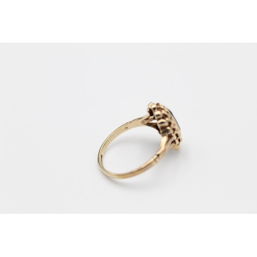 84 - A 9ct gold ornate garnet set ring, size O - approx. gross weight 2.6 grams