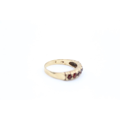 74 - A 9ct gold garnet set half eternity ring, size O - approx. gross weight 2.7 grams