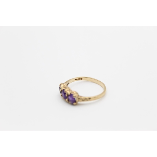 132 - A 9ct gold amethyst three stone ring, size O - approx. gross weight 2.1 grams