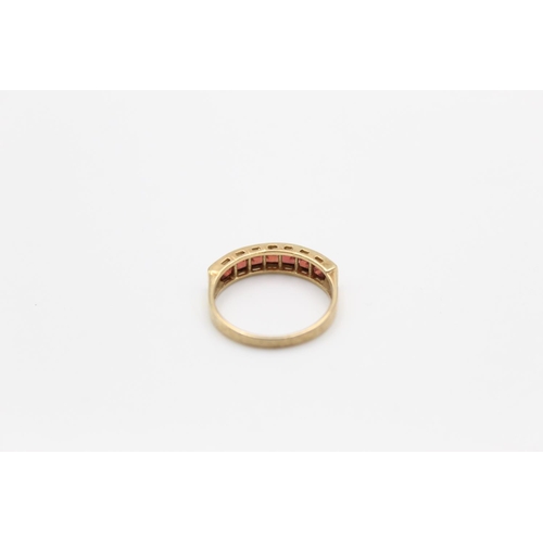 141 - A 9ct gold garnet band ring, size M½ - approx. gross weight 2.1 grams