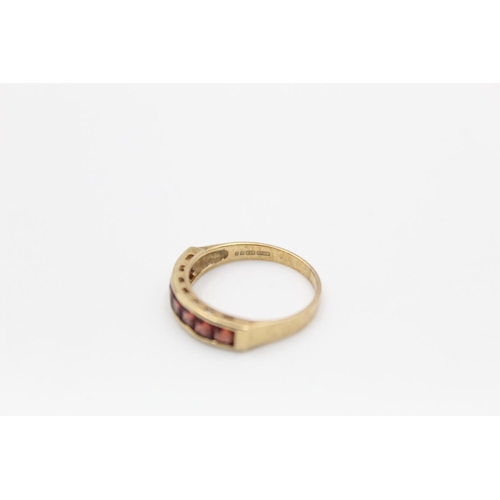 141 - A 9ct gold garnet band ring, size M½ - approx. gross weight 2.1 grams